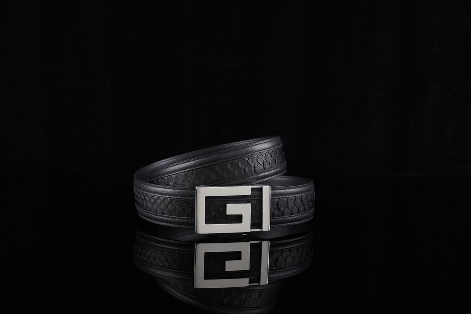 Elegant black leather belt with unique buckle design against a dark background.