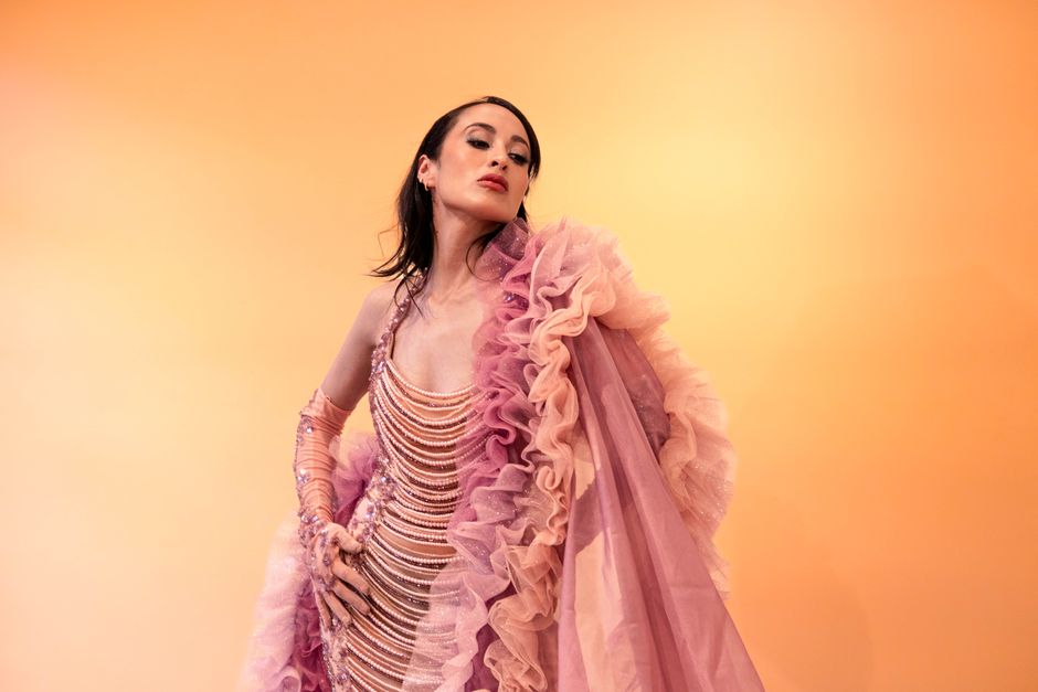 A striking fashion portrait featuring an elegant woman in a ruffled gown.