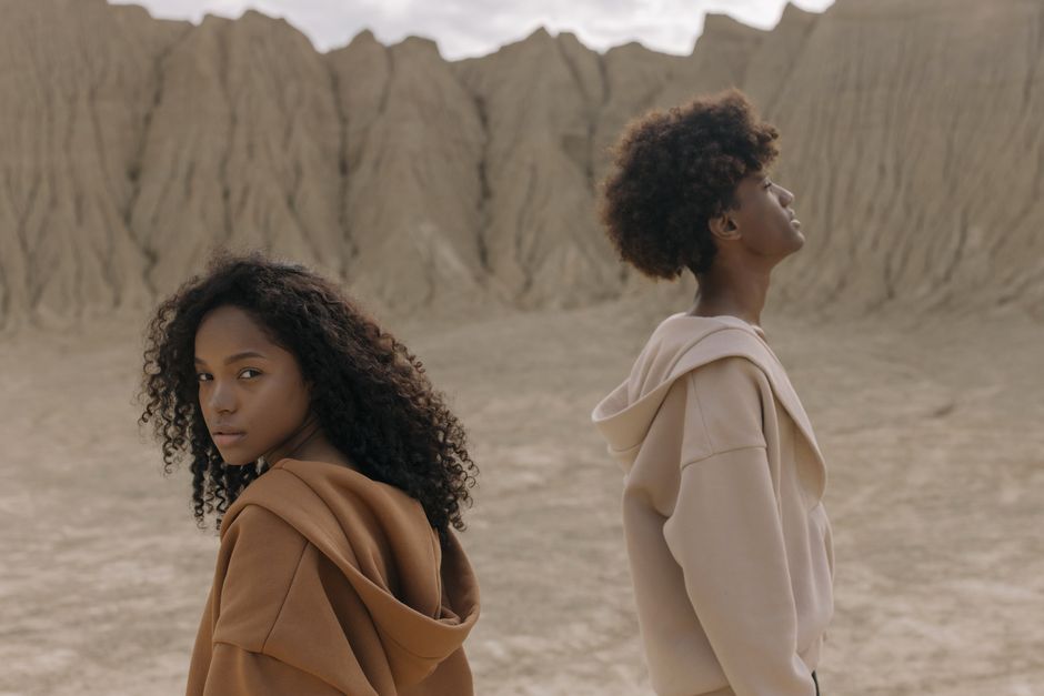 Young models wearing hoodies in a dramatic desert landscape. Perfect for fashion and lifestyle themes.