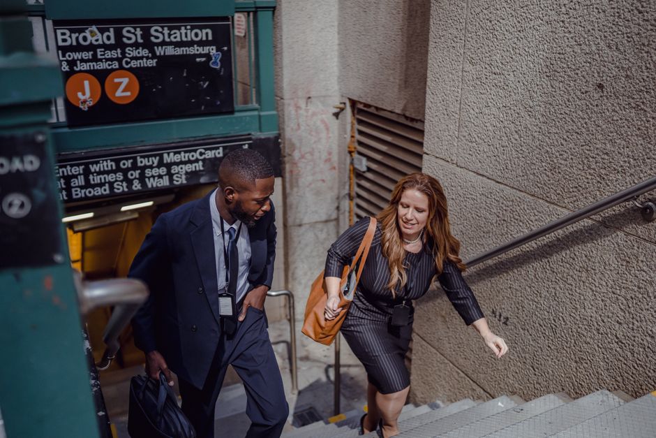 Two business professionals in suits walking up stairs at Broad Street Station.