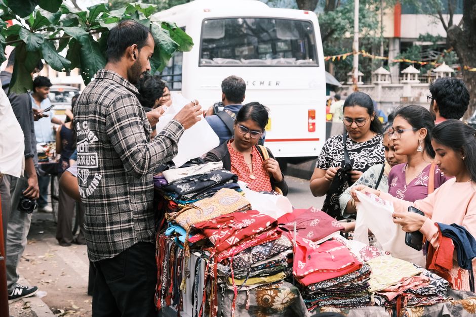 People shopping at a bustling street market stall in Bengaluru, India.