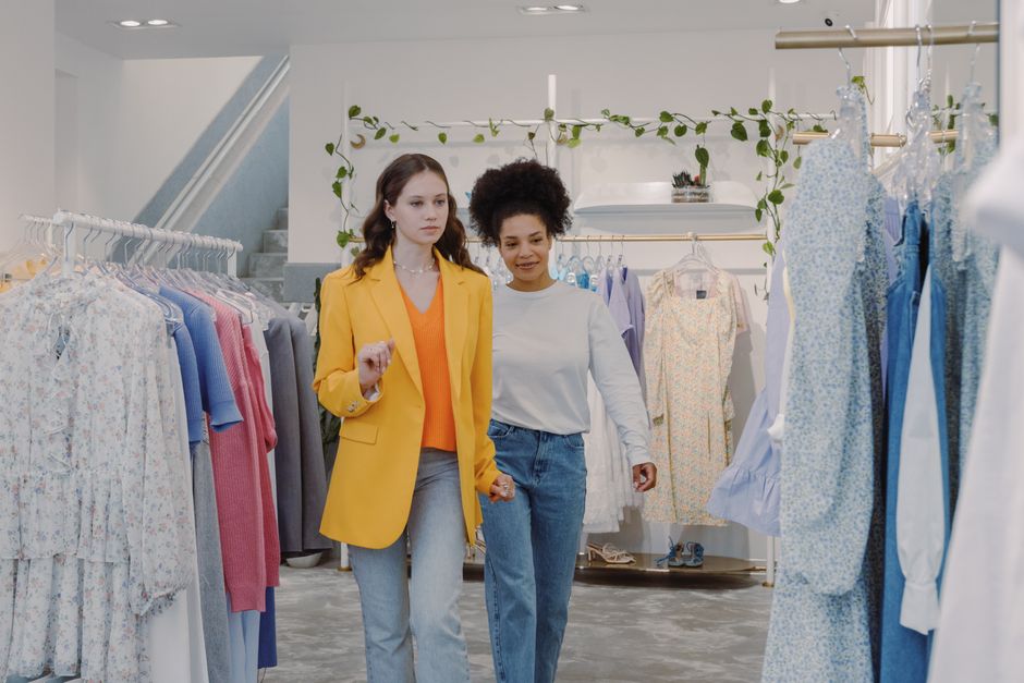 Two women exploring fashion trends in a stylish boutique together.