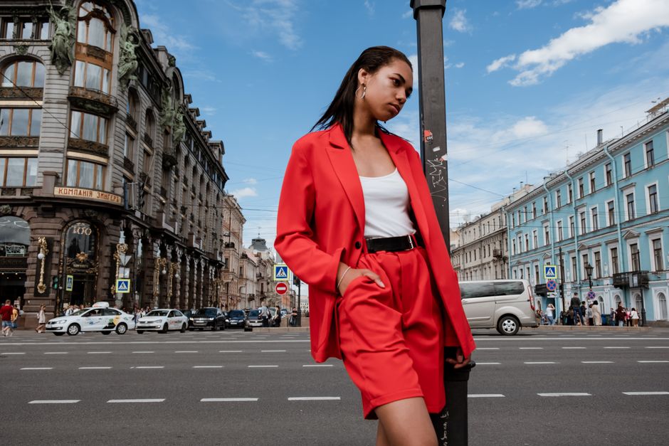 Fashionable woman in a red suit posing on Nevsky Prospekt, Saint Petersburg.