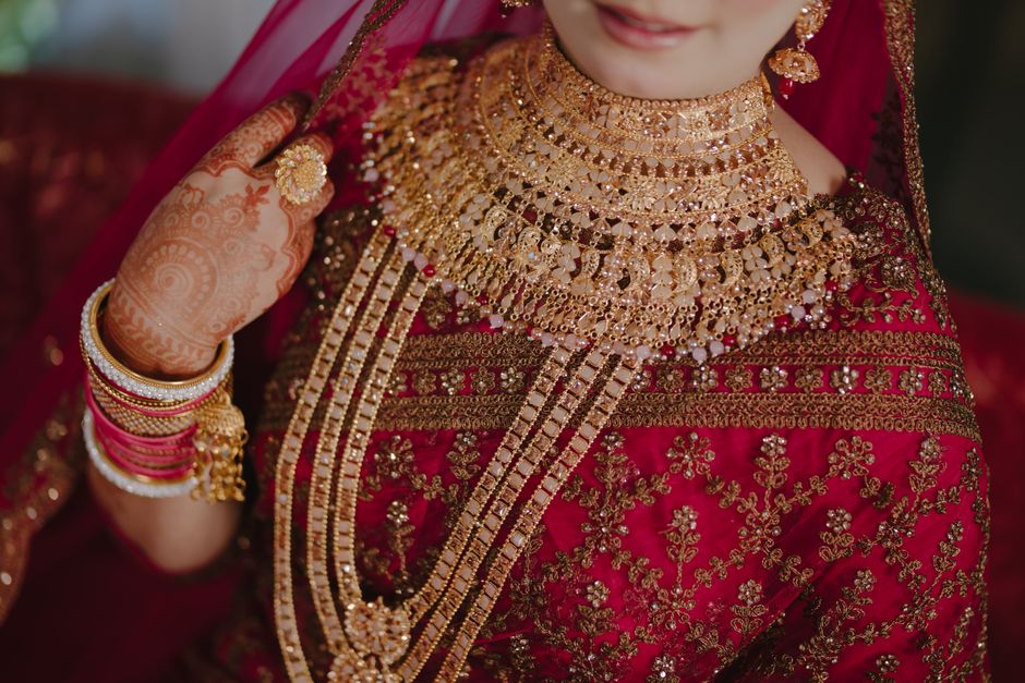 Close-up of a bride's intricate jewelry and traditional attire, showcasing cultural elegance.