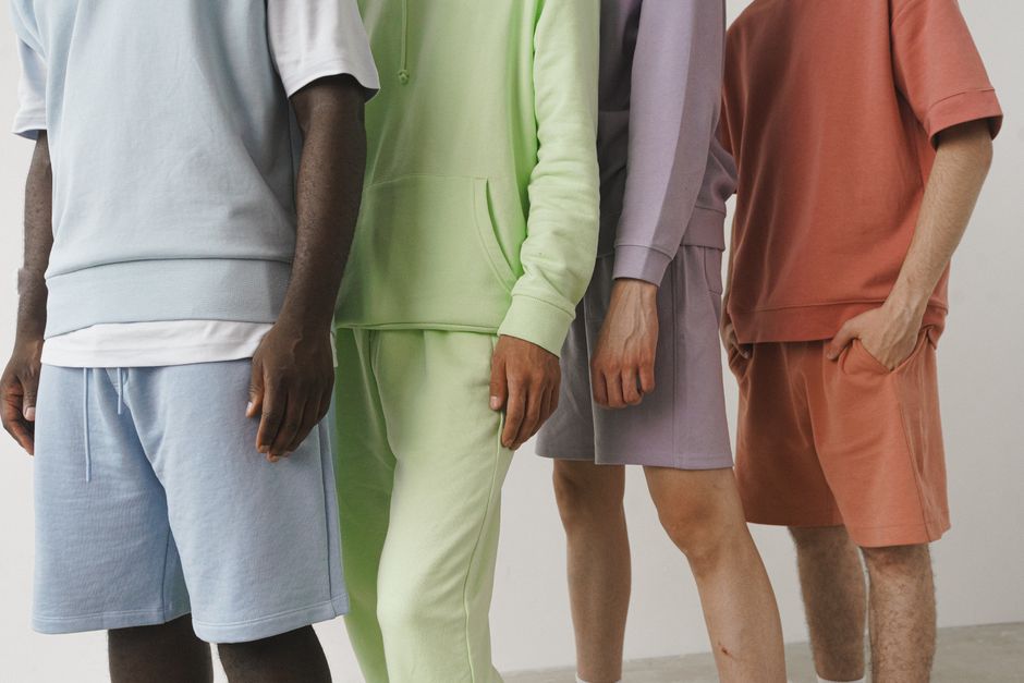 A close-up image showcasing a variety of pastel-colored men's fashion sweatshirts and shorts.