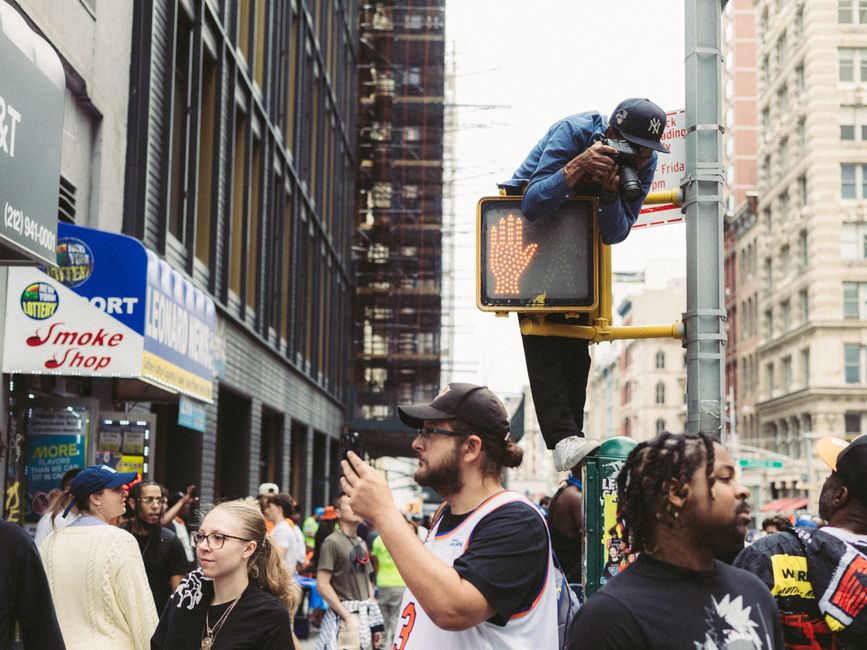 Dynamic street scene in NYC with a photographer capturing the vibrant urban life.