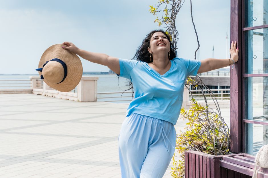 Woman in a straw hat enjoying a sunny day by the waterfront in Baku, Azerbaijan.