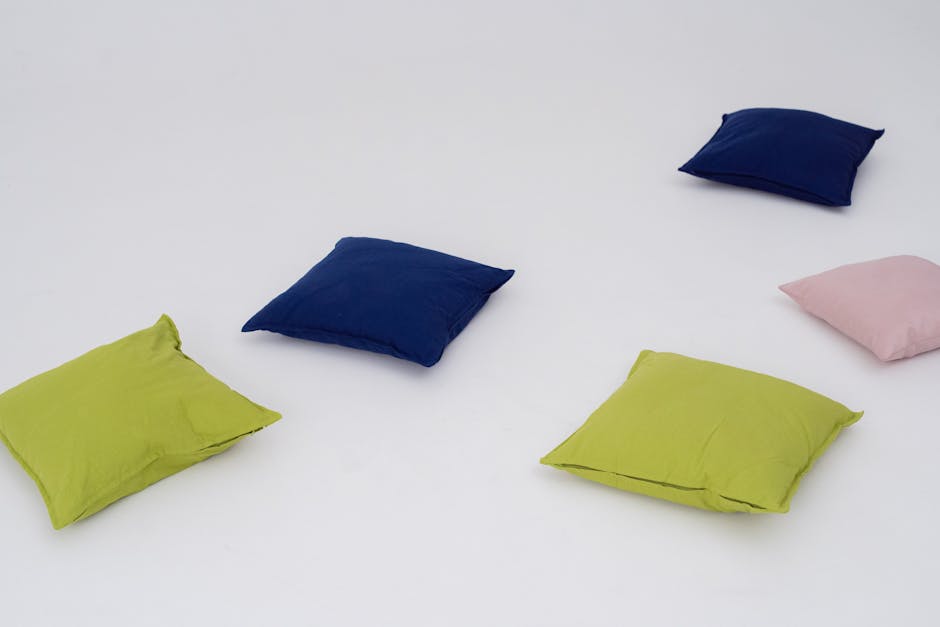 Vibrant green, blue, and pink throw pillows spread on a white background.